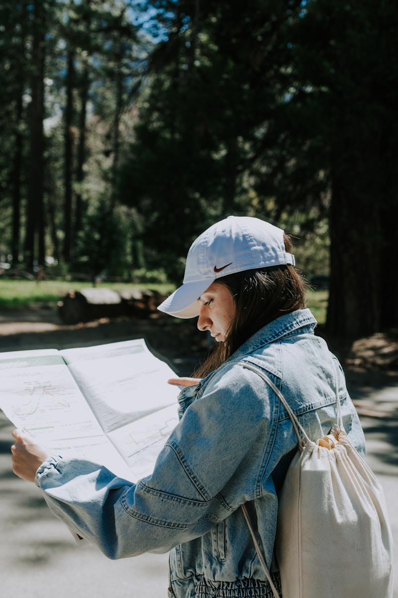 Woman reads a map in a forest.